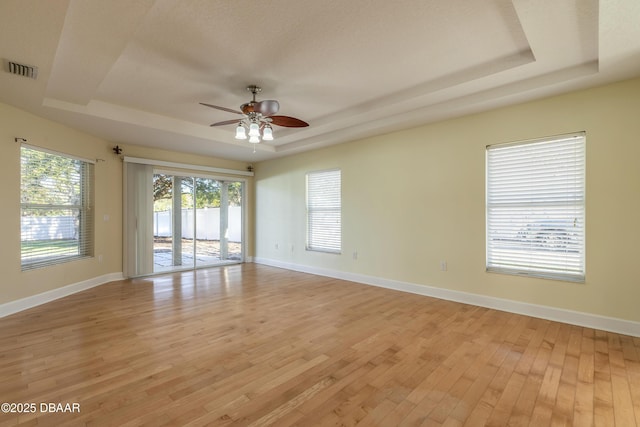 bedroom featuring access to outside, a raised ceiling, ceiling fan, and light hardwood / wood-style floors