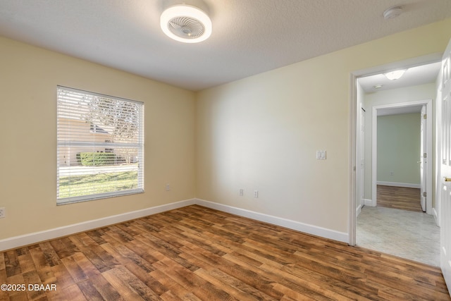 spare room featuring wood-type flooring and a textured ceiling