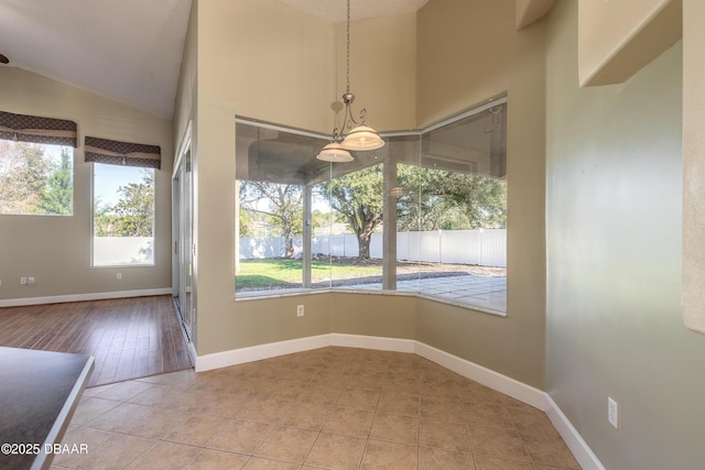 unfurnished dining area featuring tile patterned floors and lofted ceiling