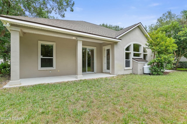 back of house with a patio and a lawn