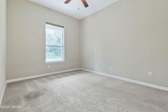 carpeted spare room featuring ceiling fan