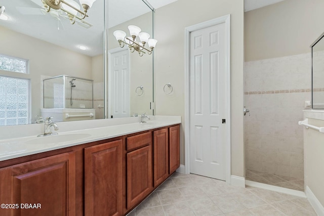 bathroom with vanity, tile patterned flooring, a notable chandelier, and tiled shower