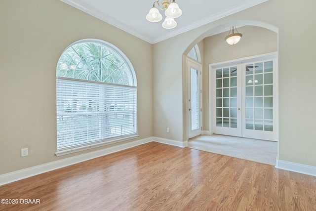 entryway with a notable chandelier, french doors, light hardwood / wood-style flooring, and ornamental molding