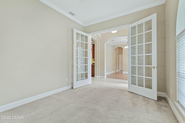 carpeted spare room with ornamental molding and french doors