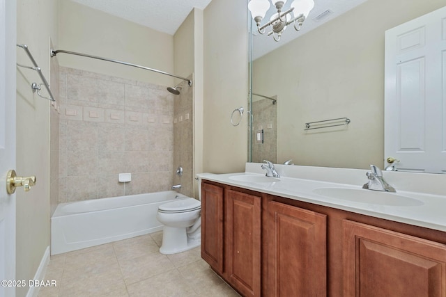 full bathroom with toilet, tile patterned flooring, an inviting chandelier, tiled shower / bath combo, and vanity