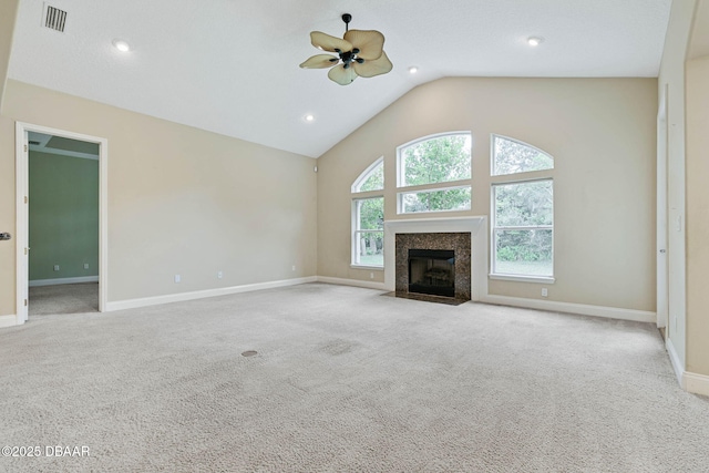 unfurnished living room featuring ceiling fan, light carpet, a high end fireplace, and lofted ceiling