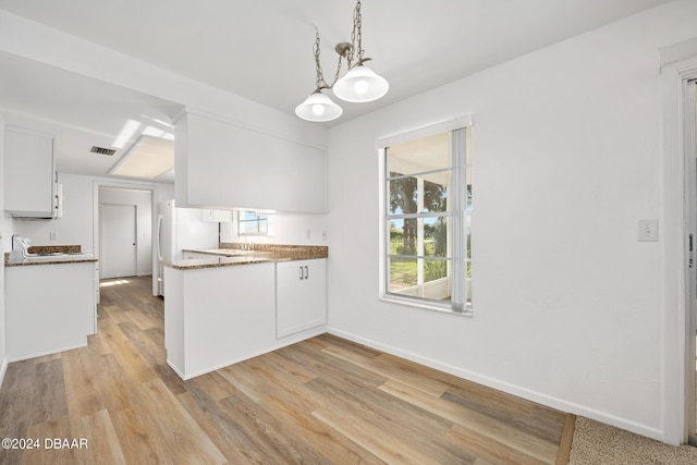 36 Dresden Cir, Ormond Beach, FL 32174 - kitchen with white cabinets, light wood finished floors, baseboards, pendant lighting, and a peninsula