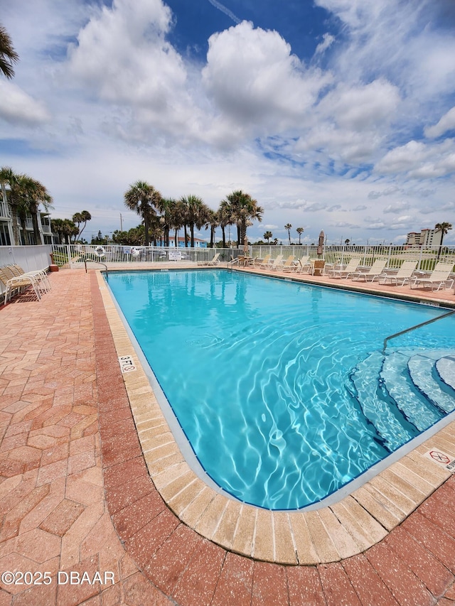 community pool featuring a patio and fence