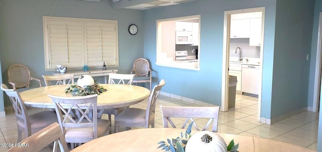 dining space with baseboards and light tile patterned floors