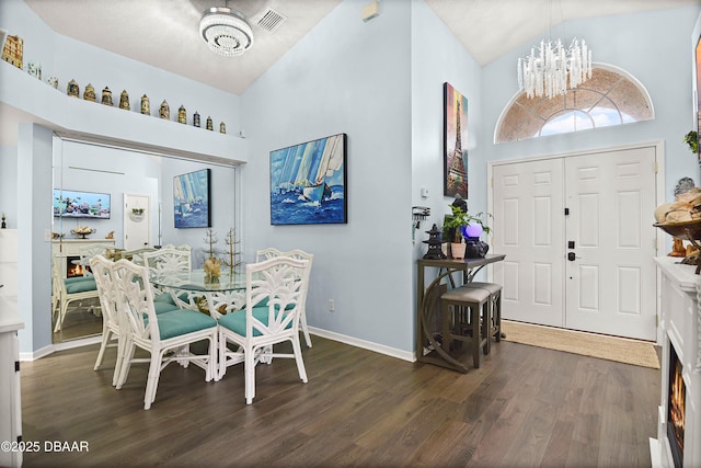 dining area with wood finished floors, a notable chandelier, high vaulted ceiling, and visible vents