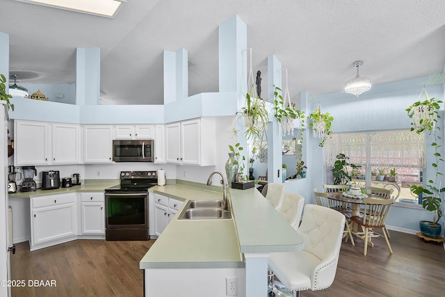 kitchen featuring light countertops, white cabinets, a peninsula, stainless steel appliances, and a sink