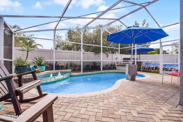 view of pool with a fenced backyard, a pool with connected hot tub, a lanai, and a patio area