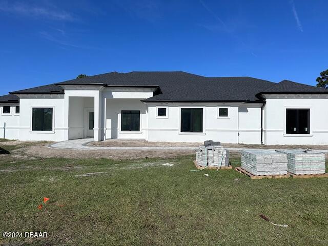 rear view of house featuring a yard