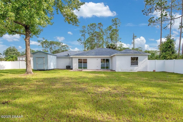 rear view of house featuring central AC, a storage unit, and a lawn