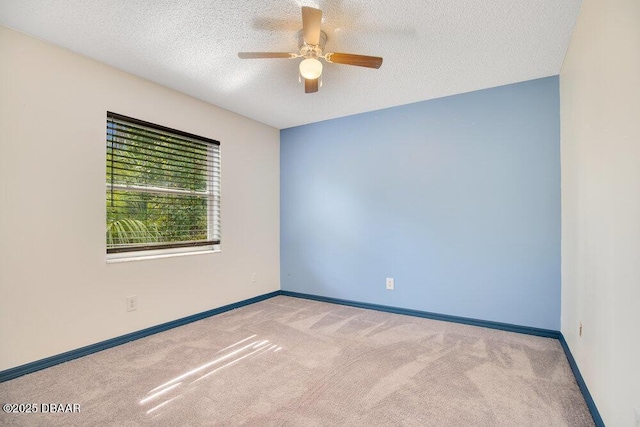 carpeted spare room with ceiling fan and a textured ceiling