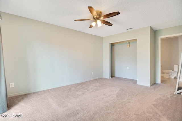 unfurnished bedroom featuring ceiling fan, light colored carpet, a closet, and a textured ceiling