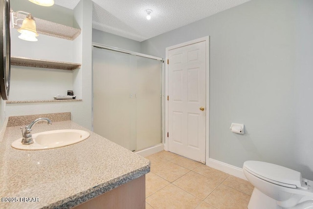 bathroom featuring tile patterned flooring, vanity, a textured ceiling, and walk in shower