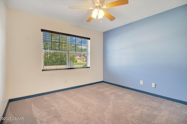 carpeted spare room featuring ceiling fan and a textured ceiling