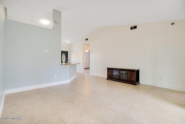 unfurnished living room with lofted ceiling and light tile patterned floors