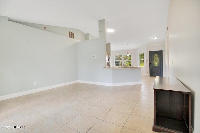 unfurnished living room with light tile patterned flooring and lofted ceiling