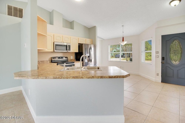 kitchen featuring sink, light tile patterned floors, appliances with stainless steel finishes, kitchen peninsula, and pendant lighting