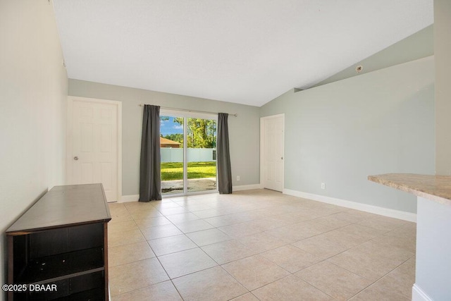 tiled spare room with lofted ceiling