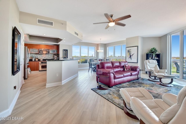 241 Riverside Dr Unit 410, Holly Hill, FL 32117 - living room with light wood-style flooring, ceiling fan, and baseboards