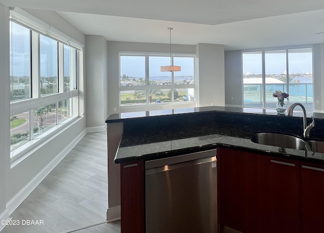 241 Riverside Dr Unit 410, Holly Hill, FL 32117 - kitchen featuring stainless steel dishwasher, a sink, dark stone countertops, baseboards, and hanging light fixtures