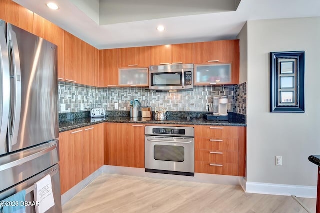 241 Riverside Dr Unit 410, Holly Hill, FL 32117 - kitchen featuring stainless steel appliances, modern cabinets, dark stone countertops, glass insert cabinets, and recessed lighting