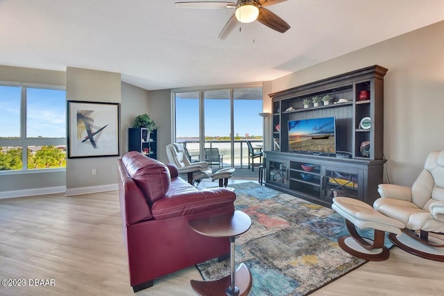 241 Riverside Dr Unit 410, Holly Hill, FL 32117 - living area with healthy amount of natural light, wood finished floors, baseboards, and a ceiling fan