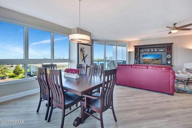 241 Riverside Dr Unit 410, Holly Hill, FL 32117 - dining space featuring wood finished floors, a ceiling fan, baseboards, and a fireplace