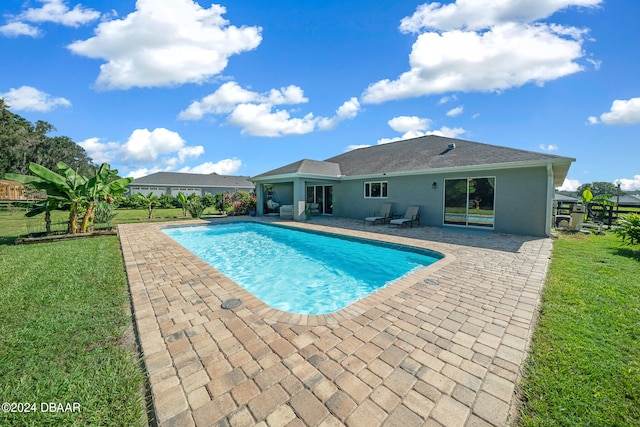 view of pool featuring a patio and a yard