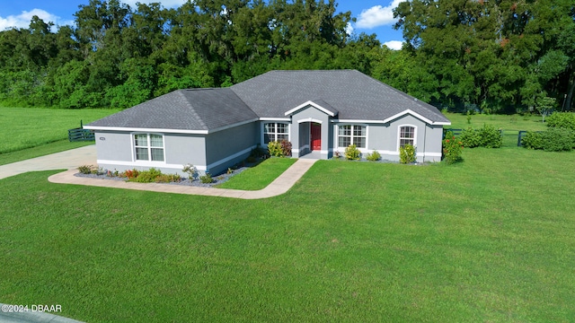 ranch-style home with stucco siding and a front lawn