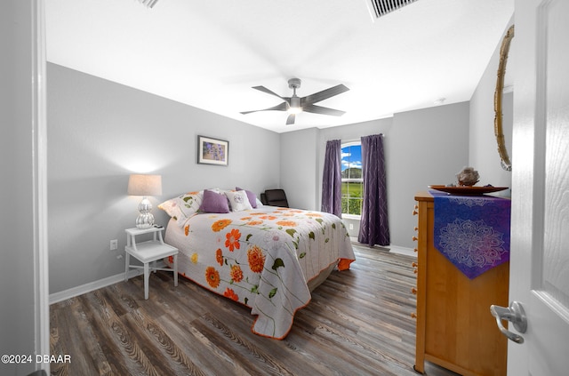 bedroom with dark hardwood / wood-style flooring and ceiling fan