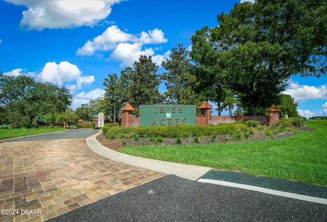 community / neighborhood sign featuring a yard