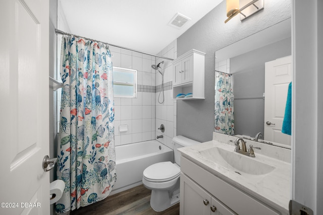 full bathroom featuring hardwood / wood-style floors, vanity, shower / bath combo with shower curtain, and toilet