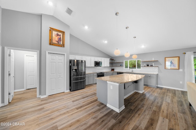 kitchen with a kitchen island, pendant lighting, appliances with stainless steel finishes, and a healthy amount of sunlight