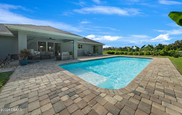 view of swimming pool with ceiling fan, a patio, and an outdoor living space