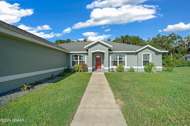 1934 NW 79th Loop, Ocala, FL 34475 - ranch-style home with a front yard, stucco siding, and roof with shingles