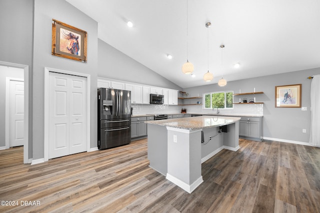 kitchen featuring appliances with stainless steel finishes, a kitchen bar, high vaulted ceiling, gray cabinets, and pendant lighting