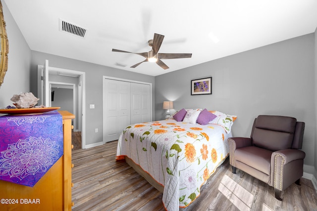 bedroom with a closet, hardwood / wood-style flooring, and ceiling fan