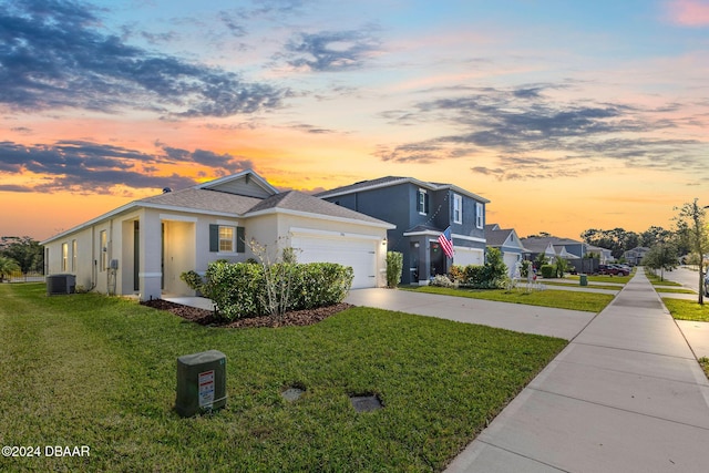 view of front of home with central AC unit and a lawn