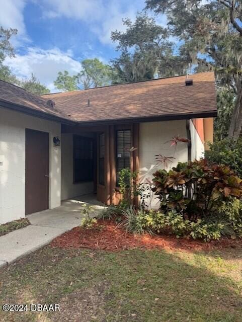 property entrance featuring a lawn