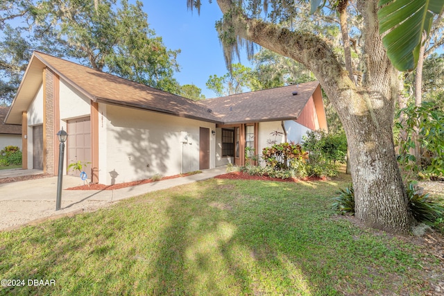 single story home featuring a garage and a front lawn