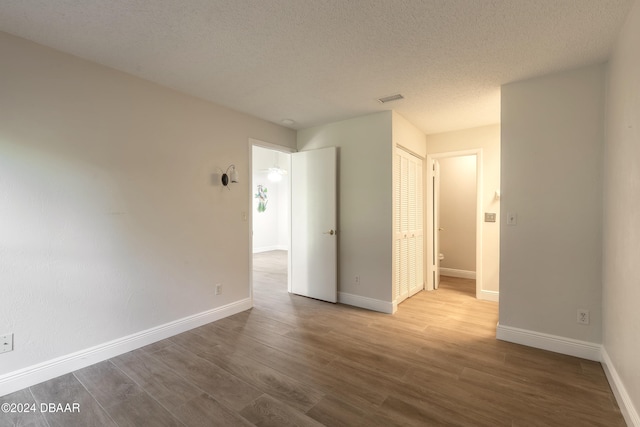 empty room featuring a textured ceiling and hardwood / wood-style flooring