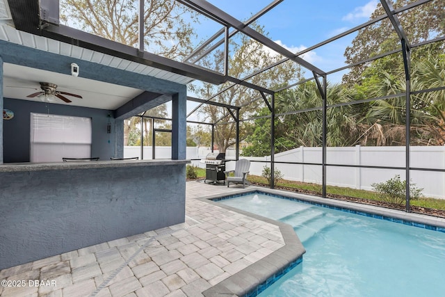 view of swimming pool featuring glass enclosure, fence, a fenced in pool, area for grilling, and a patio area