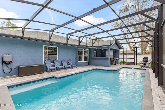 view of pool featuring a patio area, glass enclosure, and a fenced in pool