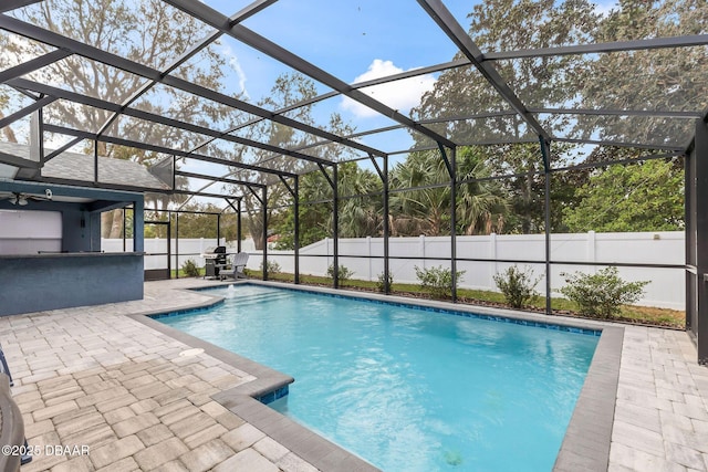 view of swimming pool featuring outdoor dry bar, a fenced in pool, a lanai, a fenced backyard, and a patio area