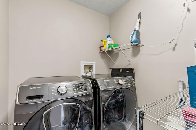 laundry room featuring washer and dryer, a textured ceiling, and laundry area