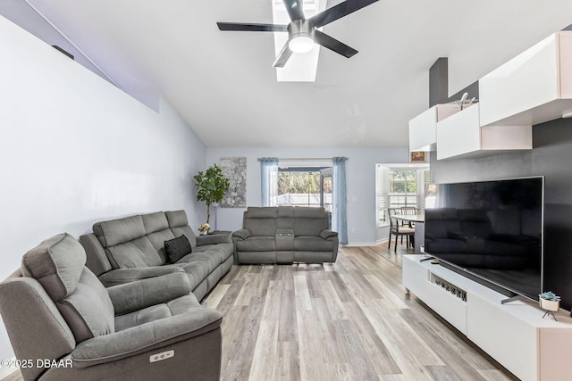 living area with ceiling fan, baseboards, lofted ceiling, and light wood-style floors